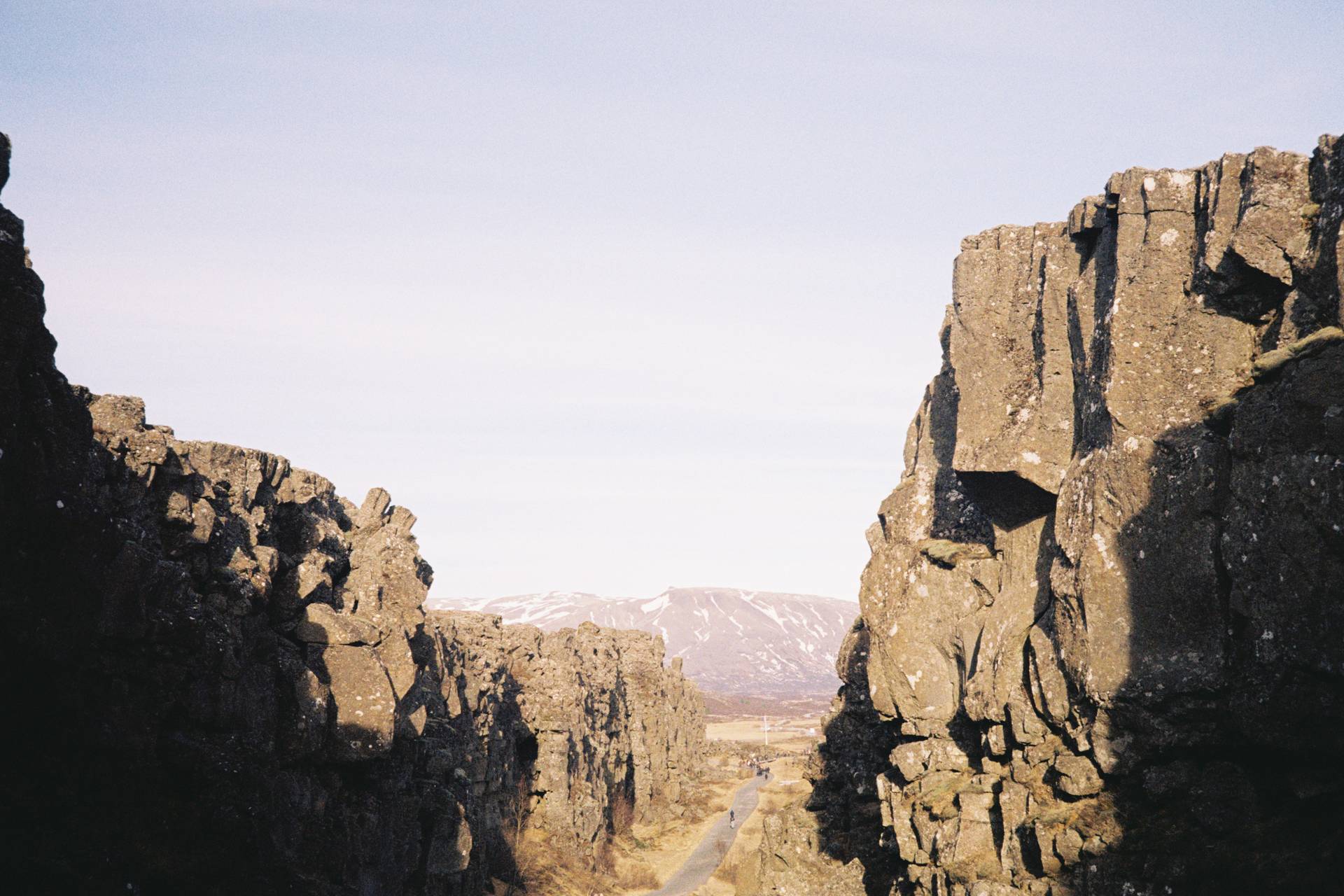 A photograph of a fault line carved out of the ground, with a path running down the middle