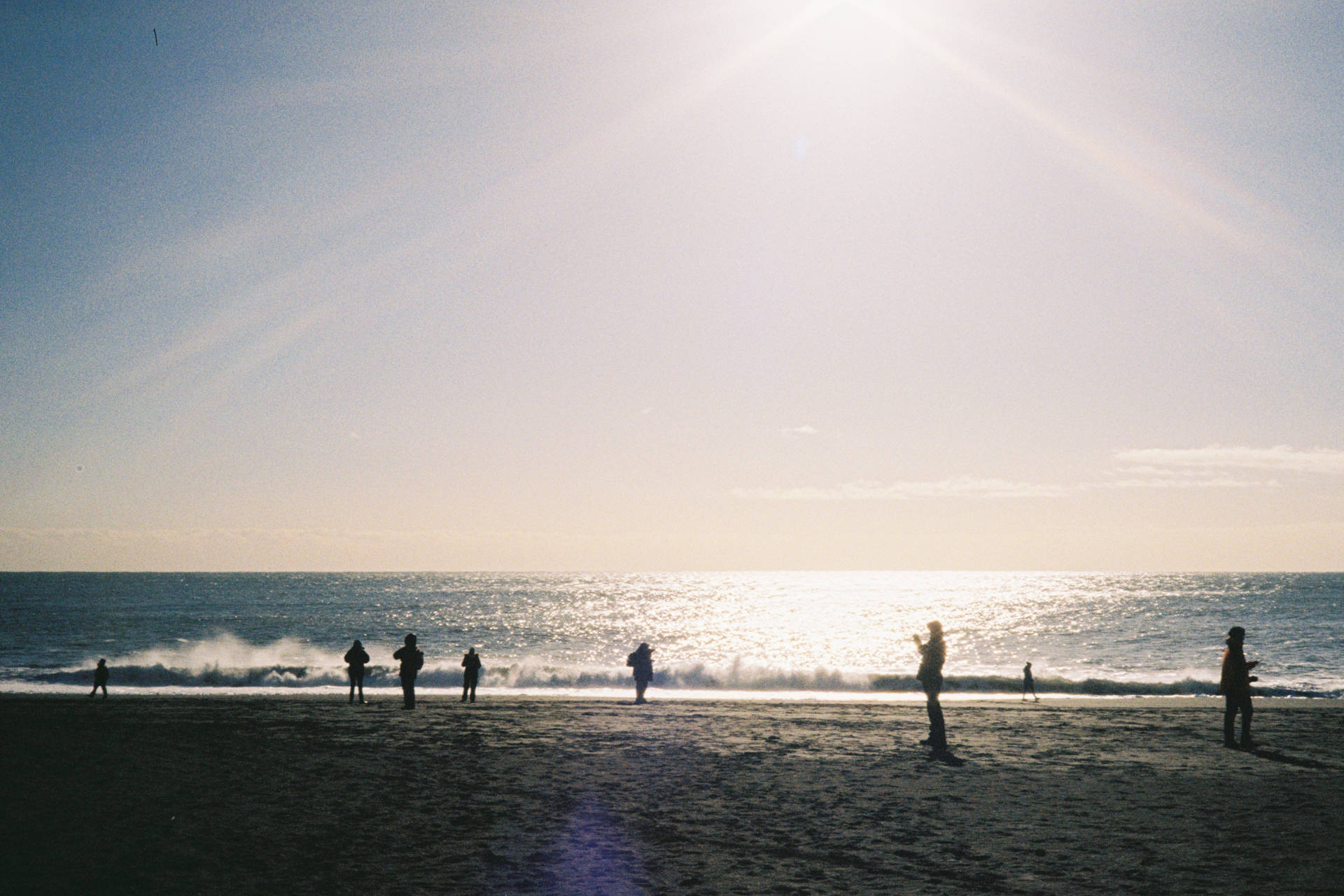 A photograph of the black sand beach, including several people taking pictures of themselves